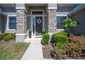 Close up of the front door with stone pillars, tasteful wreath and manicured shrubs at 5531 Pebble Beach Dr, Lakeland, FL 33812