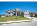 Charming single-story home with well-maintained landscaping, gray stucco, stone accents and a two-car garage at 5531 Pebble Beach Dr, Lakeland, FL 33812