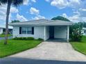 Attractive single-story home featuring a carport, well-maintained lawn, and tropical landscaping at 602 Avery Ln # 602, Lakeland, FL 33803