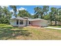 A charming single-story home with a well-manicured lawn, inviting entrance, and an attached two-car garage at 6735 Forestwood W Dr, Lakeland, FL 33811