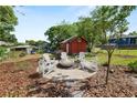 Backyard area featuring a red shed and a stylish fire pit area with seating, ideal for outdoor gatherings at 705 W Park St, Lakeland, FL 33803