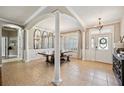 Elegant dining room featuring tile floors, architectural columns, and a modern chandelier at 7088 Remington Oaks Loop, Lakeland, FL 33810