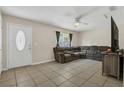 An open living room with tile floors and a large sectional sofa for ample seating at 7208 Thomas Jefferson Cir, Bartow, FL 33830
