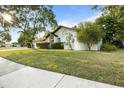 Well-maintained white single-story house with a green lawn and lush, mature trees at 781 Bryson Loop, Lakeland, FL 33809