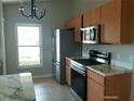 Well-lit kitchen featuring stainless steel appliances, light wood cabinets, and countertop with marble look at 7952 Grand Pines Blvd, Lakeland, FL 33810
