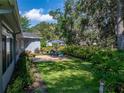 A serene backyard featuring a brick patio with outdoor seating and lush landscaping for relaxing and entertaining at 800 Osprey Landing Dr, Lakeland, FL 33813
