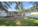 Inviting single-story home with a neatly landscaped lawn, white trim and a light blue front door at 818 Fairlane Dr, Lakeland, FL 33809