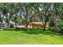 Brick home with manicured lawn, mature trees, and a neatly fenced yard in a quiet neighborhood at 909 Lake Deeson Pt, Lakeland, FL 33805