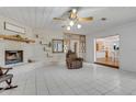 Cozy living room with tile floors, painted brick fireplace, decorative shelving, and open floor plan at 3822 Charter Rd, Lakeland, FL 33810