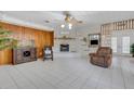 Living room with tile floors, a painted brick fireplace, wood paneled wall, and comfortable seating at 3822 Charter Rd, Lakeland, FL 33810