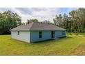 An expansive backyard featuring a lush lawn and sliding glass doors, offering a seamless indoor/outdoor flow at 10470 Sw 139Th Ct, Dunnellon, FL 34432