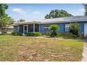 Delightful single story home with a metal roof and a screened porch, set on a lush green lawn at 120 Bolender Rd, Auburndale, FL 33823