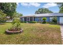 Inviting single story home with a metal roof, a screened porch, and a well-manicured lawn at 120 Bolender Rd, Auburndale, FL 33823