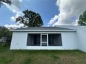 Enclosed back porch overlooking yard and featuring screen door and sliding glass doors at 1251 Dosseywood Ln, Lakeland, FL 33811