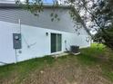 Exterior view of home featuring sliding glass door, A/C unit, and various home utilities at 1251 Dosseywood Ln, Lakeland, FL 33811