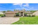 Charming single-story home with landscaped yard and brick-paved driveway under a blue sky at 146 Woodside Dr, Lakeland, FL 33813