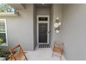 Inviting front porch with decorative door art and two cozy chairs for a welcoming entrance at 1825 Wallace Manor Ln, Winter Haven, FL 33880