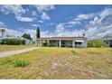 Charming single-story home with a covered carport and quaint front porch, nestled under a cloudy sky at 224 Raymond Ave, Frostproof, FL 33843