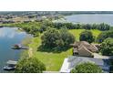 Aerial view showing a home on a lush green lawn near a lake and surrounded by trees at 254 Lake Tennessee Dr, Auburndale, FL 33823
