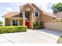 Inviting two-story home featuring a spacious driveway, mature landscaping, and a welcoming red front door at 254 Lake Tennessee Dr, Auburndale, FL 33823