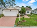 Inviting single-story home featuring a lush green lawn, fresh landscaping, and a brick-colored driveway at 3341 Highland Fairways Blvd, Lakeland, FL 33810