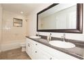 Bathroom featuring double sinks, granite countertops and framed mirrors and a tile shower at 4008 S Carlisle Rd, Lakeland, FL 33813