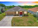 Charming single-story home with a well-maintained lawn, attached garage, and vibrant red front door at 4041 Byrds Crossing Dr, Lakeland, FL 33812