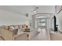 Bright living room with vaulted ceiling, neutral walls, tile flooring, and sliding glass doors at 412 Emerald Cove Loop, Lakeland, FL 33813