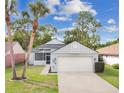 Inviting home with a manicured lawn, palm trees and attached two-car garage at 432 Sandestin Dr, Winter Haven, FL 33884
