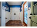 Bright foyer with blue accent wall, white wainscoting, and hardwood floors at 4825 Luce Rd, Lakeland, FL 33813
