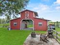 Rustic barn with open doors, a cozy fire pit area, and an inviting outdoor seating space at 511 Hickory Hammock Rd, Lake Wales, FL 33859