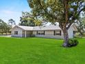 Inviting home exterior with lush green lawn and mature shade tree, creating a serene setting at 511 Hickory Hammock Rd, Lake Wales, FL 33859