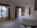 Bright living room with large windows and sliding glass door, featuring neutral carpet and high ceilings at 612 Forest Lake Dr, Lakeland, FL 33809