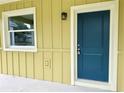 Close up view of the home's front door and surrounding siding and window at 625 W 9Th St, Lakeland, FL 33805