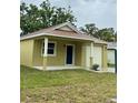 Quaint single-Gathering home with a light yellow exterior, a small lawn, and a one-car garage at 625 W 9Th St, Lakeland, FL 33805