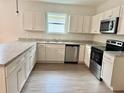 Bright kitchen features white cabinetry, stainless steel appliances, and light countertops at 625 W 9Th St, Lakeland, FL 33805