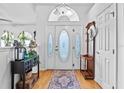 Bright foyer features a decorative glass door, wood floors, and stylish decor at 647 Hart Lake Dr, Winter Haven, FL 33884