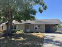 Single-story home showing covered carport, small garden, and a large shade tree in the front yard at 6610 Chippendale Rd, Lakeland, FL 33809