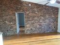 Spacious living room with a vaulted ceiling, brick wall, and hardwood floors, filled with natural light at 676 Jessanda Cir, Lakeland, FL 33813