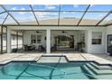 Relaxing covered lanai featuring a swimming pool, spa, ceiling fans and outdoor seating at 6777 Bentridge Dr, Lakeland, FL 33813