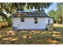 The exterior of the house features white siding, a green metal roof covered in leaves, and a well-kept lawn at 6949 2Nd St, Mulberry, FL 33860