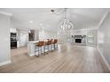 Open floor plan features wood floors, a stone fireplace, kitchen island with seating, and a chandelier at 707 Laurel Pointe Ct, Lakeland, FL 33813