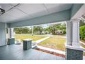 Inviting front porch with classic columns and a view of the neighborhood street at 717 Frank Lloyd Wright Way, Lakeland, FL 33803
