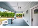 Cozy front porch with painted wood floors and pillars at 717 Frank Lloyd Wright Way, Lakeland, FL 33803