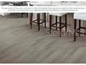 Wood-style flooring featuring white barstools underneath a large island with overhang at 7550 Sw 108Th St, Ocala, FL 34476