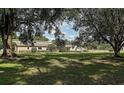This single-story home features a large, lush front yard with mature trees at 7721 Forest Way, Lakeland, FL 33810