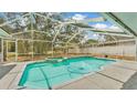 Inviting screened-in pool with attached spa and lush backyard views at 7741 Merrily Way, Lakeland, FL 33809
