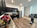 Modern kitchen with stainless steel appliances, granite countertops, and dark cabinets at 879 Grandin St, Davenport, FL 33837