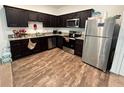 Contemporary kitchen with stainless steel appliances, dark wood cabinets, and granite countertops at 879 Grandin St, Davenport, FL 33837