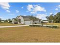 Spacious home featuring a three-car garage, well-kept landscaping, and a large yard at 8909 N Campbell Rd, Lakeland, FL 33810